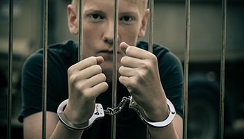 Young boy behind prison bars