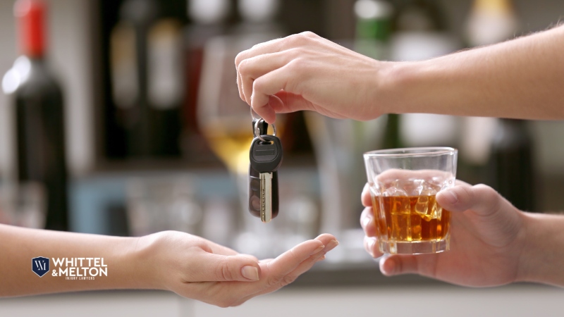 Handing over car keys while holding a glass of whiskey, symbolizing DUI and legal defense in Polk County.